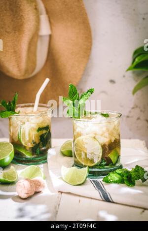 Glasses with cold alcohol Mojito cocktail with cava and fresh limes served with ice and mint leaves on tabl Stock Photo