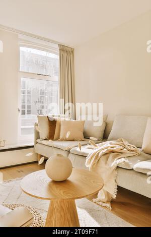 Interior of modern living room with empty couch by bright window at contemporary home Stock Photo