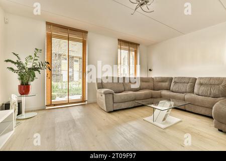 Interior of contemporary living room with couch and glass coffee table in front of white wall Stock Photo