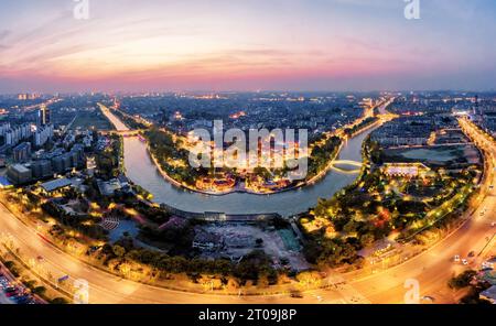 An aerial view of the city of Yangzhou in China, featuring Dashuiwan Park, Beijing-Hangzhou Grand Canal and the skyline illuminated by night lights Stock Photo