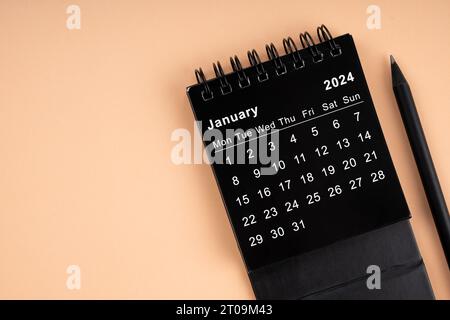 January 2024 Black spiral desktop calendar on red textile Stock Photo ...