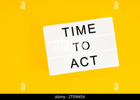 Time to act text on white lightbox sitting on yellow background. Horizontal composition with copy space. Stock Photo