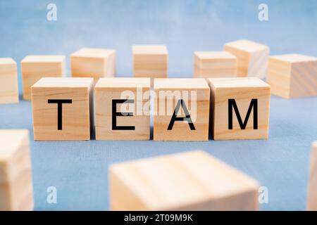 TEAM written on wooden cubes surrounded by a lot of blank cubes on old gray background. Business concepts. Stock Photo