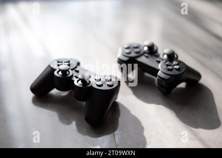 Two black gamepads on table. Gaming, leisure and entertainment concept Stock Photo