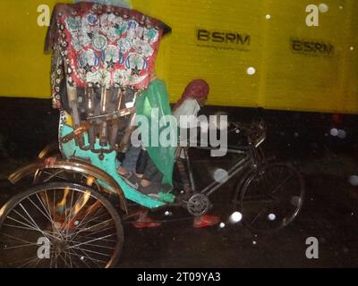 Dhaka, Bangladesh. 5th Oct, 2023. A rickshaw passenger uses a plastic sheet to protect from rain in Dhaka. The capital's daily life was reportedly disrupted by a continuous rain depression. (Credit Image: © MD Mehedi Hasan/ZUMA Press Wire) EDITORIAL USAGE ONLY! Not for Commercial USAGE! Stock Photo