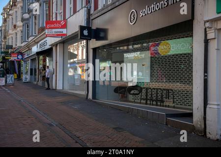 Apple store run by solutions inc in Old Chirstchurch road Bournemouth town centre in 2023 has a lot of boarded shops in the high street Stock Photo