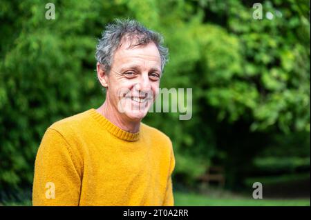 Portrait of a 55 yo white man, smiling and wearing a yellow sweater, Koekelberg, Brussels, Belgium Stock Photo