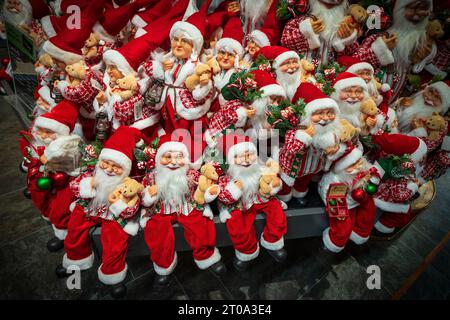 A bunch of happy santas. Dolls dressedas father Christmas on sale in store. Stock Photo