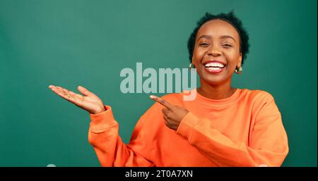 Beautiful Black woman uses palm gesturing upwards looking to copy space Stock Photo