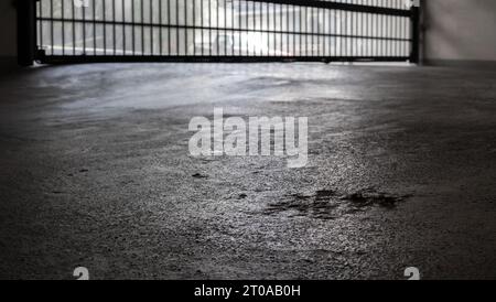 Defocused parking garage gate with focus on driveway, low angle. Secure 2 level underground parkade with fob access. Elastomeric traffic deck coating Stock Photo