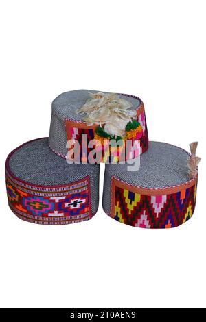 closeup the bunch colorful hand made indian traditional cap with hanging white flowers isolated on white background. Stock Photo