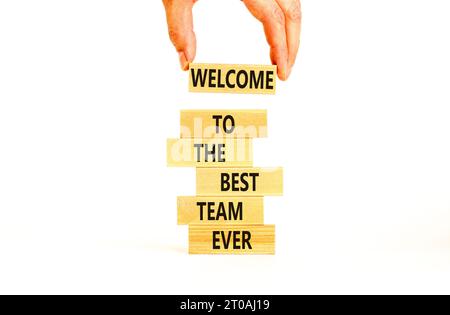 Welcome to best team symbol. Concept words Welcome to the best team ever on wooden block. Beautiful white table background. Businessman hand. Business Stock Photo