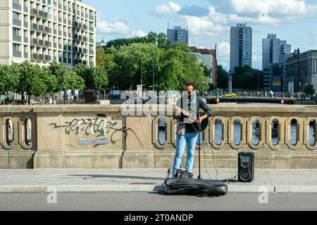 Berlin, Germany, July 20: Street musician guitarist performs his songs on a bridge in Berlin on July 20, 2023. Stock Photo