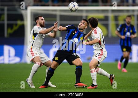 Lautaro Martinez of FC Internazionale competes for the ball with Orkun Kokcu of SL Benfica and Joao Neves of SL Benfica during the UEFA Champions League football match between FC Internazionale and SL Benfica. Stock Photo