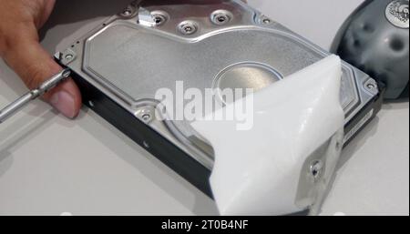 Close-up of an open hard disk drive in the hands of a technician Stock Photo