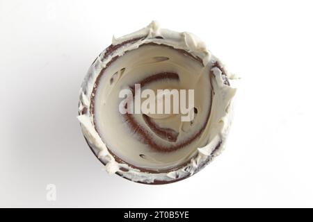 Empty unwashed bowl with leftover cream isolated on white background. Remains of a delicious dessert, sour cream, yogurt Stock Photo