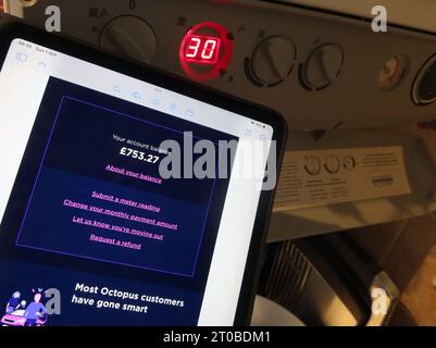 iPad tablet with Octopus monthly costs, near central heating boiler, in domestic property, semi-detached home, Cheshire, England, UK Stock Photo