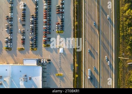 Large parking lot of local dealer with many brand new cars parked for sale on highway roadside. Development of american automotive industry and distri Stock Photo