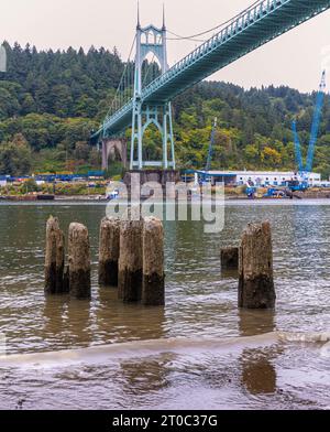 Wooden Remains of Old Ferry Landing and The Gothic -Cathedral Styled St. Johns Bridge, Portland, Oregon, USA Stock Photo