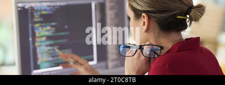 Female programmer checkups code working on computer Stock Photo