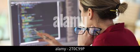 Female programmer checkups code working on computer Stock Photo
