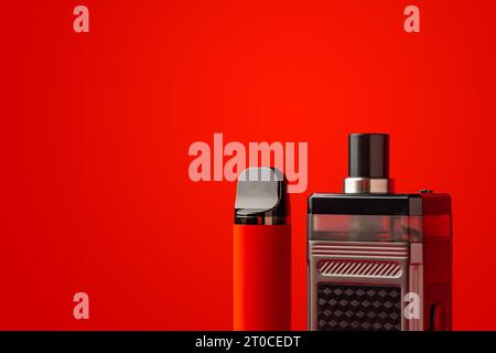 Disposable electronic cigarettes on red background close up Stock Photo