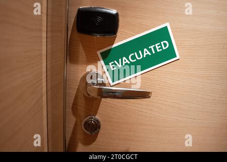 Schiffskabine mit einem Schild Evacuated Tuer einer Schiffskabine mit einem gruenen Schild und weissen Buchstaben auf dem das Wort Evacuated steht. Dieses Symbolbild signalisiert, dass die Kabine im Inneren verlassen wurde und betont die Bedeutung von Sicherheitsmaßnahmen an Bord des Schiffes Barcelona Spanien *** Ship cabin with a sign Evacuated Door of a ship cabin with a green sign and white letters on which is written the word Evacuated This symbol image signals that the cabin inside has been abandoned and emphasizes the importance of security measures on board the ship Barcelona Spain Stock Photo