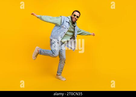 Full length size body cadre freedom careless guy hipster style youth denim style outfit dancing isolated on bright yellow color background Stock Photo