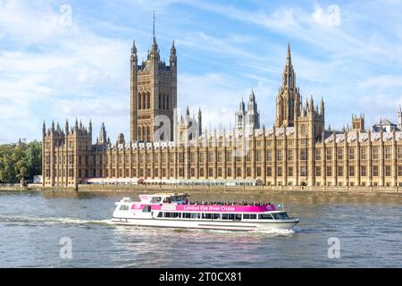 Cruise boat passing Houses of Parliament on River Thames, South Bank, London Borough of Lambeth, Greater London, England, United Kingdom Stock Photo