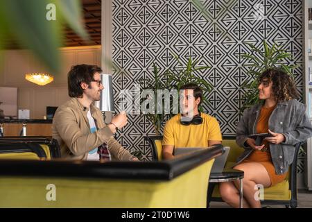 Happy males and female professionals sharing ideas while sitting in hotel lobby Stock Photo