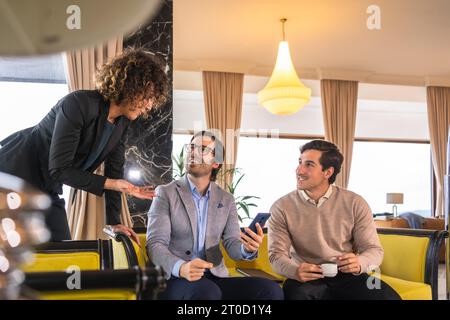 Start up meeting between woman and two men in the hall of an hotel Stock Photo