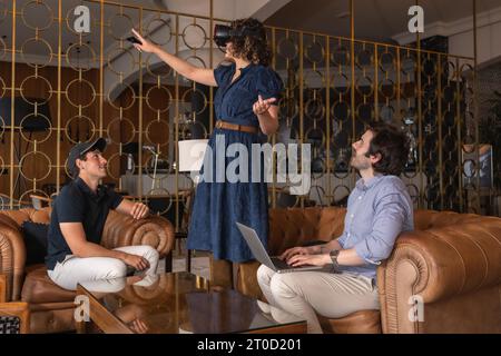 Colleagues testing a new game on virtual reality simulator in an hotel reception Stock Photo