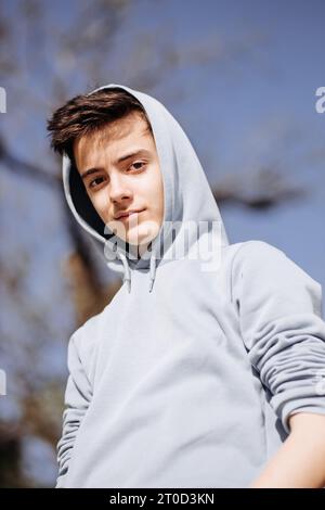 Portrait of adolescent in casual clothes at blue sky background. Stock Photo