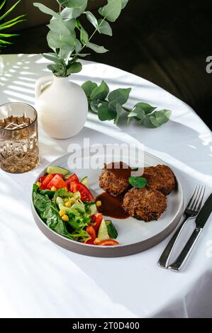 grilled beef patties with fresh vegetables on a plate Stock Photo