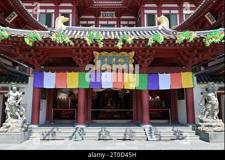 Entrance to the main hall of the Buddha Tooth Relic Temple in Chinatown, Singapore, flanked by stone statues of fierce protective guardians Stock Photo