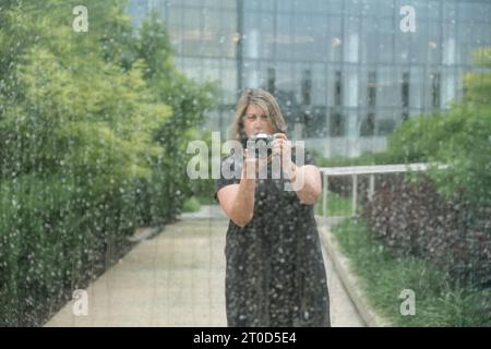 Portrait of woman taking selfie in urban park. Stock Photo