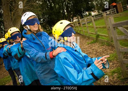 Secondary school pupils walking blindfold on an outward bound course Stock Photo