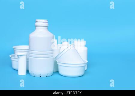 Different empty plastic waste packages on blue background with negative space Stock Photo