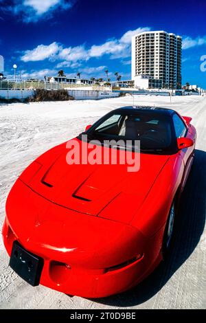 Red Pontiac Firebird Trans Am 1995 series 3 model parked on the sand at Daytona Beach, Florida, USA Stock Photo