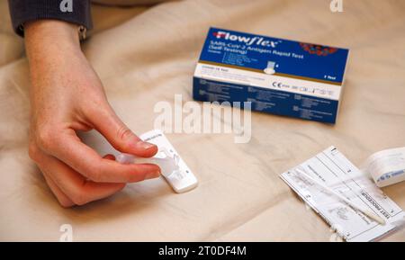 A girl does a Flowflex SARS-Cov-Antigen Rapid Test and gets a positive result for the Covid-19 virus. Stock Photo