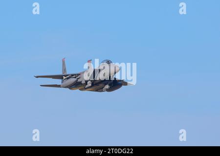 American military F15 jet aircraft flying isolated in a clear blue sky. Stock Photo