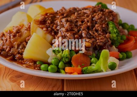 Beef and pork mince in gravy with new potatoes and mixed vegetables. Stock Photo