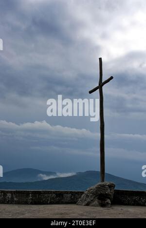 La croce dell'eremo della Verna contro il cielo nuvoloso Stock Photo