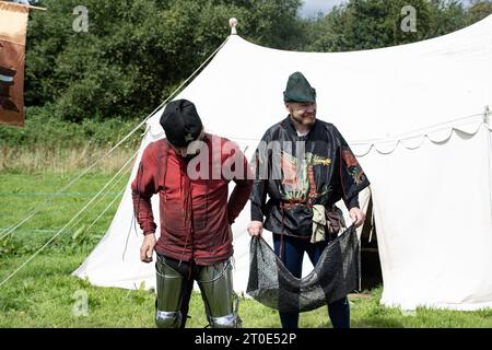 Kenilworth England  July 29th 2023 A knight  is  being  dressed by  his  squires  attaching his  armour Stock Photo