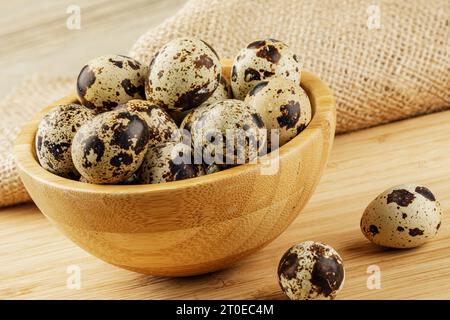 A Wooden Bowl of delicious Quail Eggs isolated on wooden background with copy space Stock Photo
