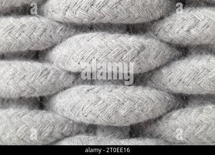 Woven basket pattern, close up. Macro of light grey large weaving pattern made of woven cotton rope. Textile background texture or surface. Selective Stock Photo