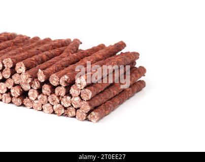 Isolated rawhide chew sticks for dogs, perspective view. Pile of chicken and beef flavoured dog chews. Dental health treats for dogs and behavioral en Stock Photo