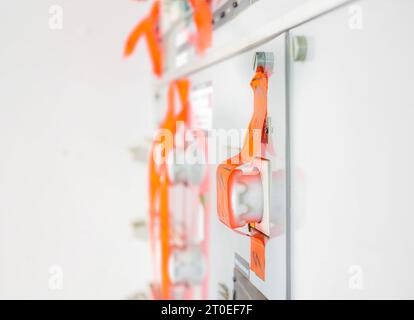 Electrical cabinet with tapes over fuses. Orange tape over multiple fuses. Power supply company shut off and taped off power due to unsafe conditions, Stock Photo