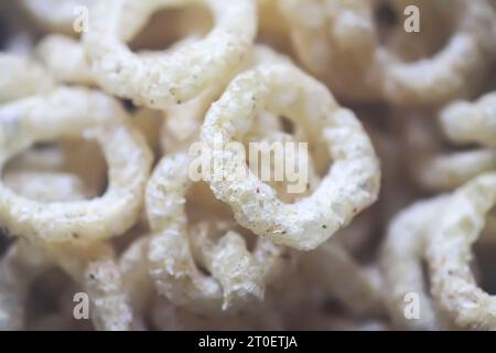 Round corn rings pile with spices. Crunchy puffed snacks close up. Stock Photo