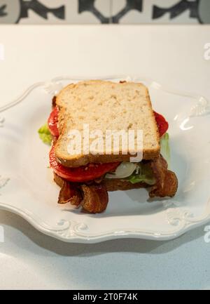 BLT, a bacon, tomato & lettuce sandwich made with oatnut bread &  served on a white plate. USA. Stock Photo